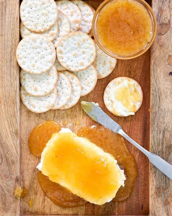 overhead view of jezebel sauce over cream cheese and crackers on a tray.