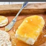 southern jezebel sauce over cream cheese and crackers on a wood tray.
