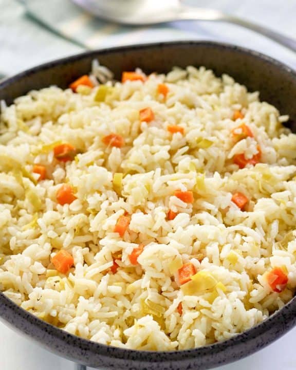 homemade rice pilaf in a black bowl and a spoon.
