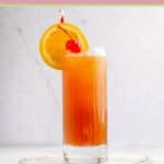 sex on the beach cocktail garnished with orange slice and cherry.