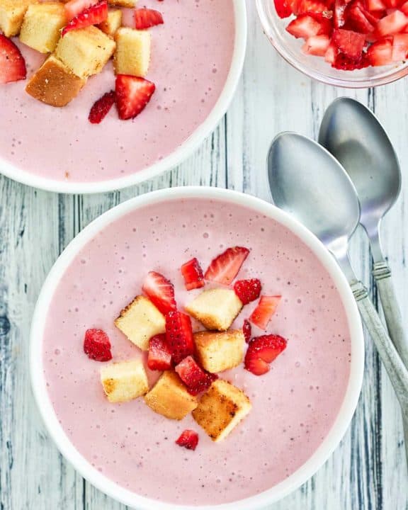 overhead view of strawberry soup with pound cake croutons.