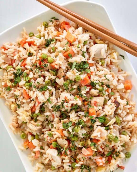 overhead view of Thai chicken fried rice and chopsticks on a platter.