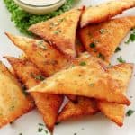 overhead view of wonton jalapeno poppers on a white plate.