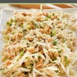 crunchy Asian slaw with ramen noodles on a white platter.