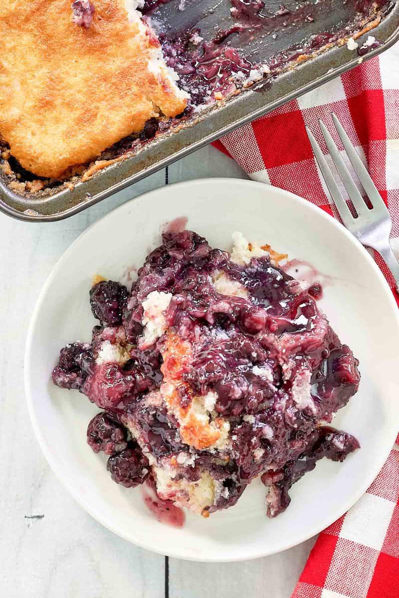 overhead view of blackberry cobbler on a plate and in a baking pan.