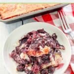 blackberry cobbler on a plate, fork, and napkin.