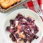overhead view of blackberry cobbler on a plate and in a baking pan.