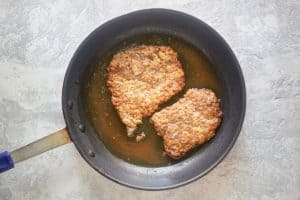 frying breaded cube steaks in a skillet.