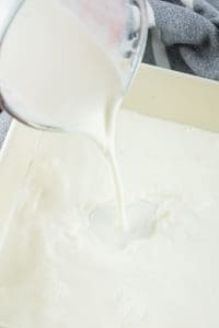 pouring half and half into a baking pan.