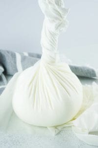 homemade cream cheese wrapped in cheesecloth.