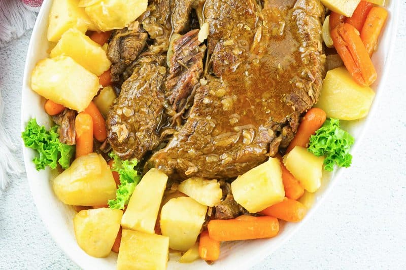 Instant Pot pot roast with gravy and vegetables on a platter.
