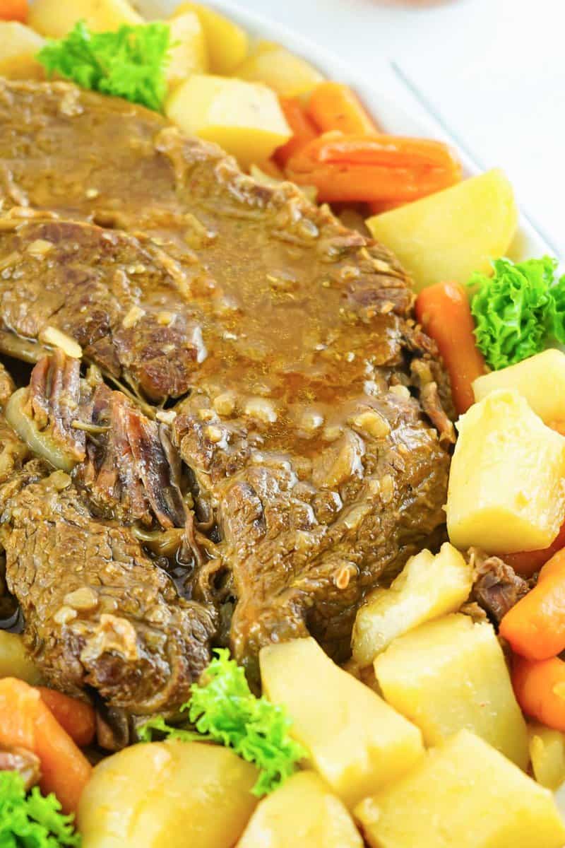 Instant pot pot roast with vegetables and gravy on a platter.