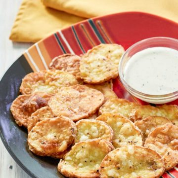 fried mojo potatoes and dipping sauce on a platter.
