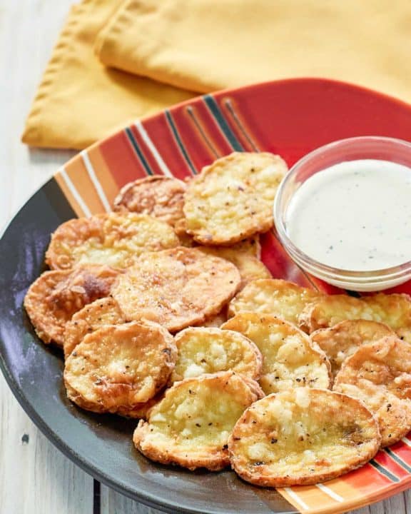 fried mojo potatoes and dipping sauce on a platter.