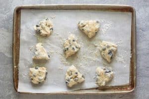 Starbucks blueberry scones on a baking sheet before baking.
