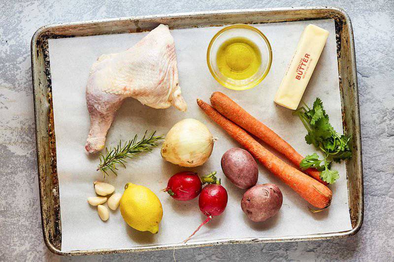 baked chicken leg quarters ingredients on a tray.