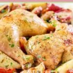 two baked chicken leg quarters and vegetables.