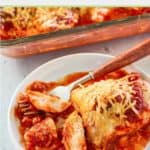 baked chicken parmesan and a fork on a plate.