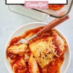 overhead view of baked chicken parmesan and a fork on a plate.