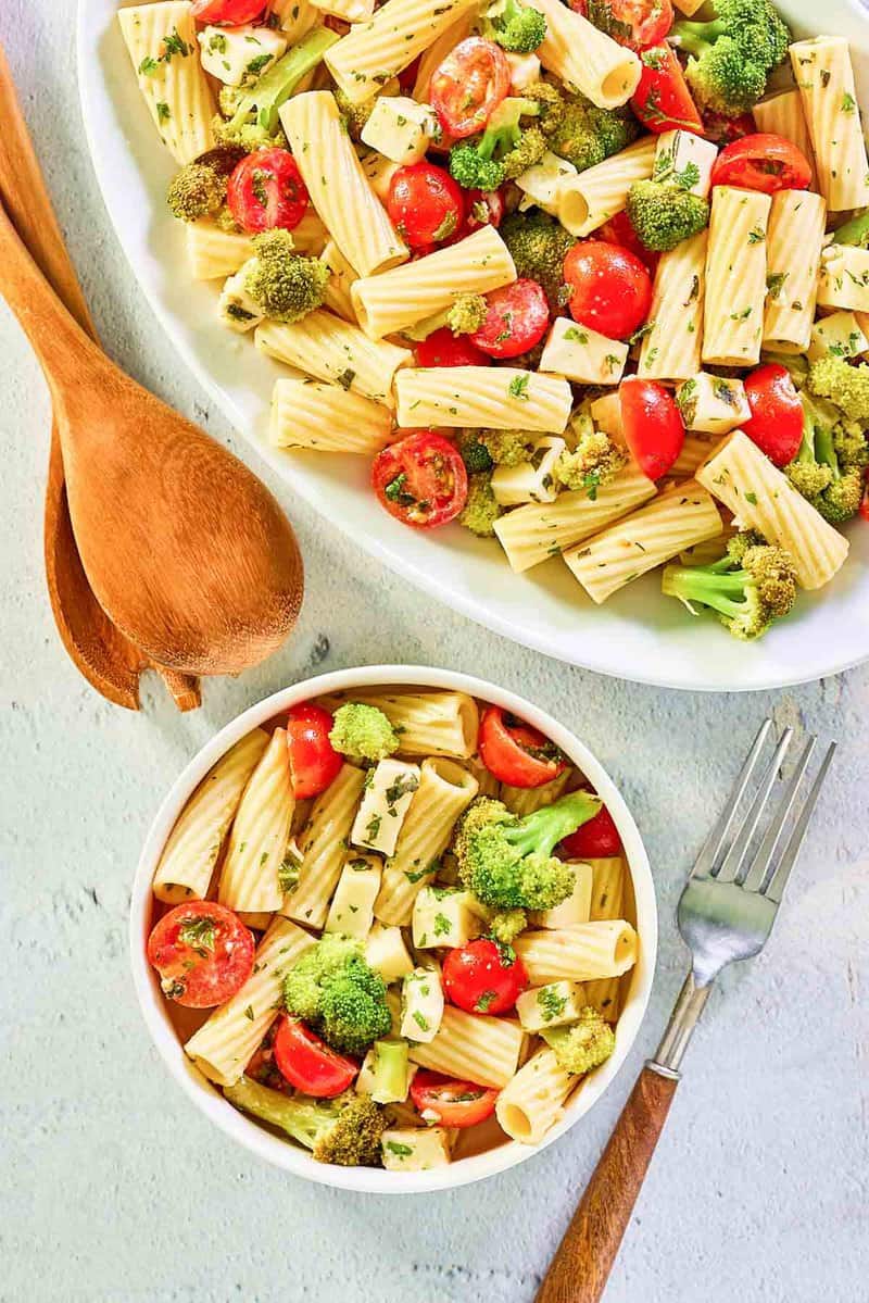 overhead view of broccoli pasta salad on a platter and in a bowl.