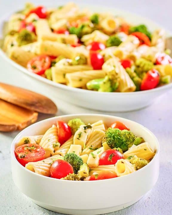 broccoli pasta salad in a bowl and on a large platter.