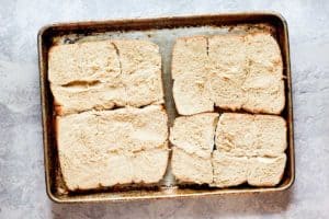 dinner roll buns for buffalo chicken sliders on a baking sheet.