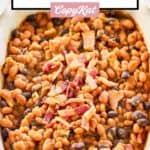 copycat cracker barrel bacon baked beans in a beige serving dish.