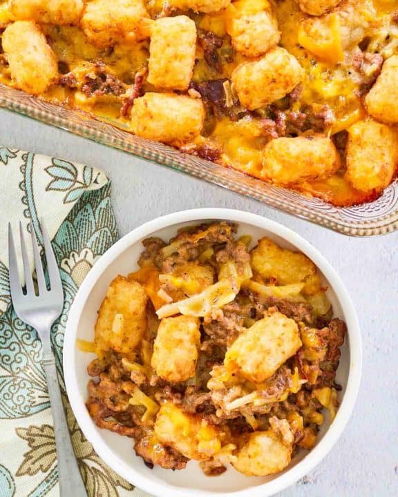 overhead view of hamburger hashbrown casserole in a baking dish and bowl.