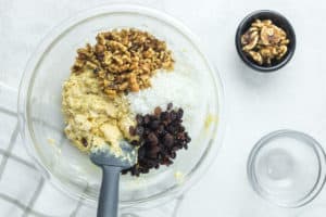 adding walnuts, coconut, and raisins to oatmeal muffin batter.
