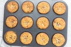overhead view of baked oatmeal raisin muffins in a muffin tin.