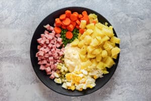 olivier salad ingredients in a large bowl.