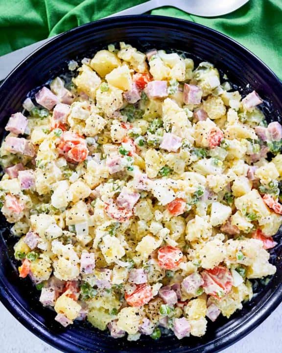 overhead view of olivier salad in a black serving bowl.