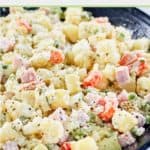 closeup of olivier salad in a black bowl.