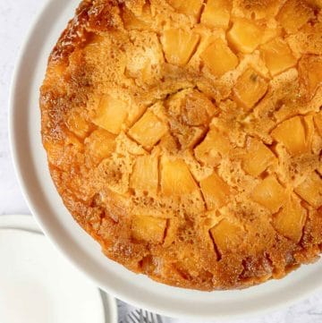 overhead view of pineapple upside down cake on a cake plate.