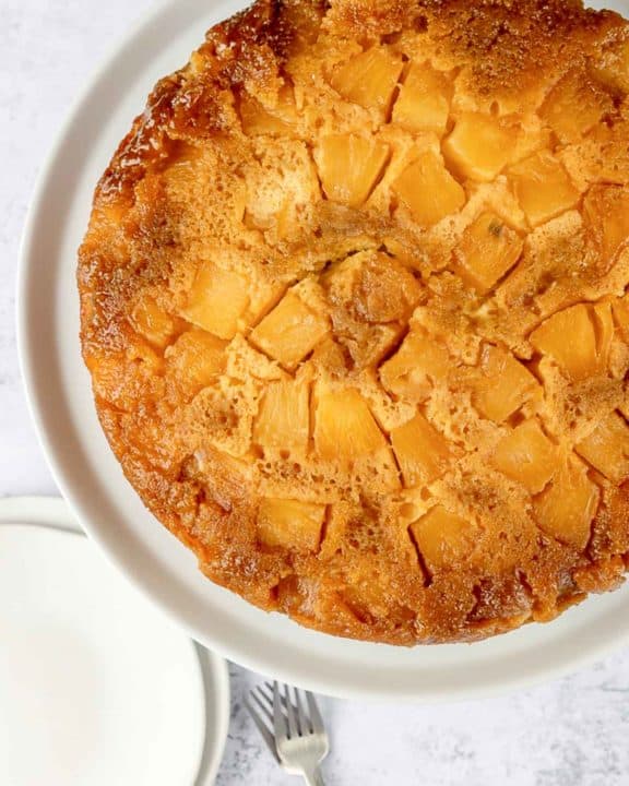 overhead view of pineapple upside down cake on a cake plate.