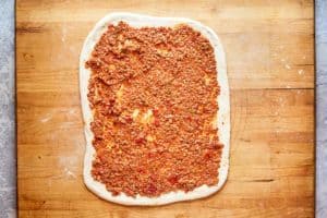 pizza dough topped with meat sauce.