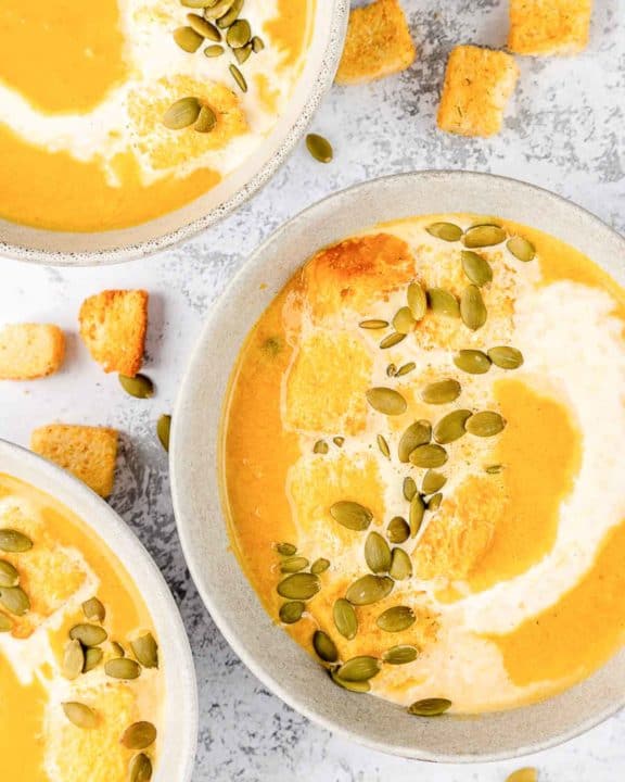 overhead view of pumpkin bisque in three bowls.