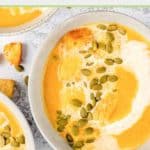 bowls of pumpkin bisque with a cream swirl and pumpkin seeds on top.