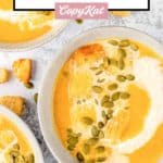 bowls of pumpkin bisque with a creamy swirl.