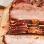 close up of smoked pork belly on a cutting board.