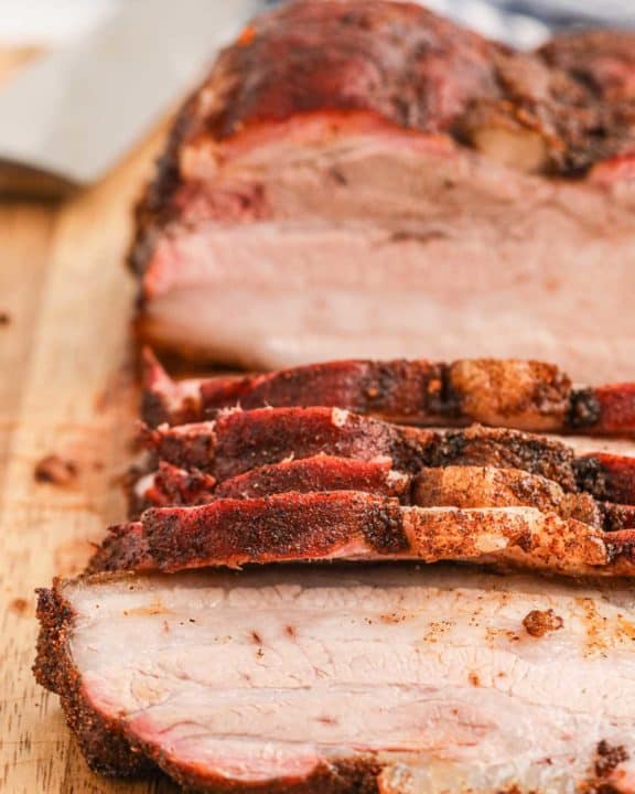 close up of smoked pork belly on a cutting board.