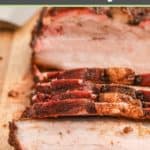 smoked pork belly cut into slices on a wood board.