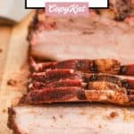 smoked pork belly slices on a wood board.
