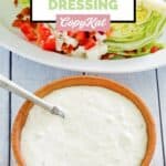 bowl of homemade blue cheese dressing next to a wedge salad.