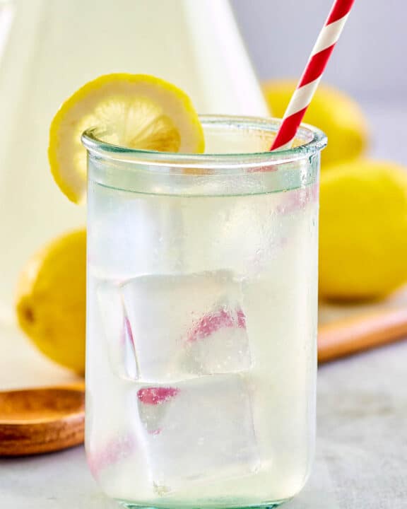 copycat Chick Fil A lemonade in a glass and pitcher.