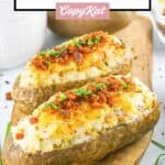 two loaded twice baked potatoes on a serving board.