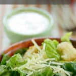 copycat Outback Steakhouse Caesar salad dressing behind a salad.