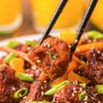 chopsticks holding a piece of homemade PF Chang's orange chicken.