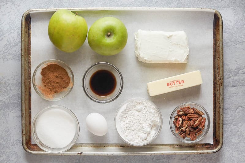 apple pie cheesecake ingredients on a tray.