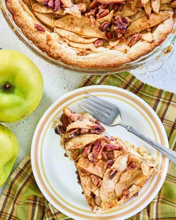overhead view of apple pie cheesecake and a slice on a plate.